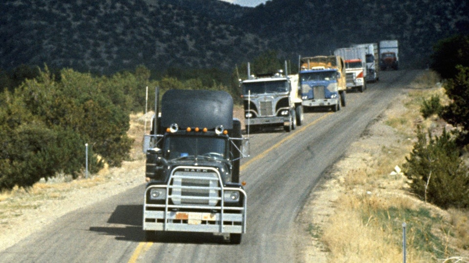 A line of trucks coming around a curve, with Rubber Duck in the lead